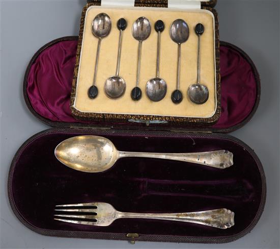A cased set of six George V silver bean end coffee spoons and a cased christening spoon and fork (knife missing).